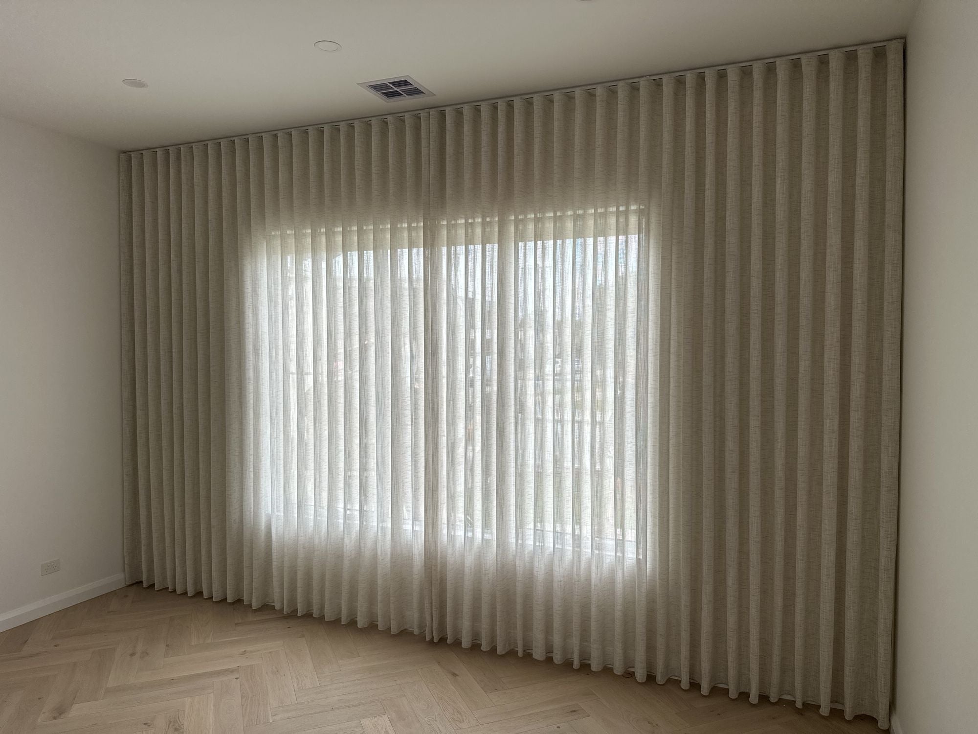 Floor-to-ceiling sheer curtains across a window